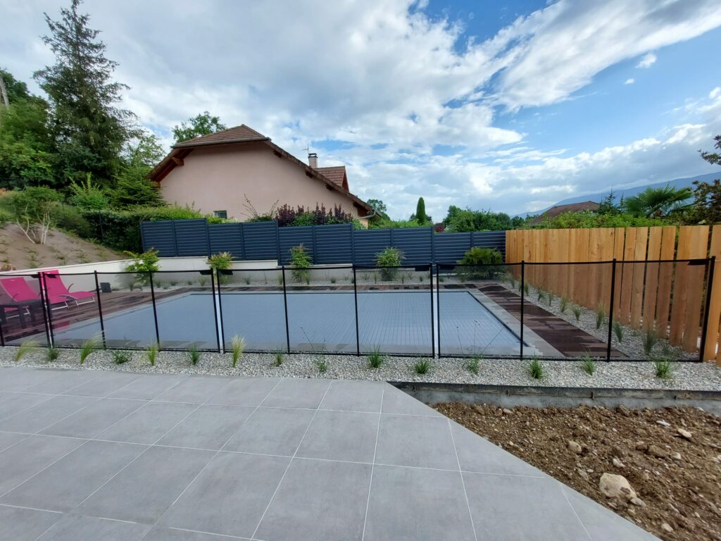 Mélange de différentes clôtures (bois, aluminium et grillage souple) pour un habillage de piscine